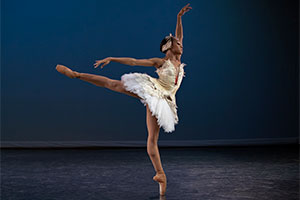 a ballerina on stage in front of a blue background