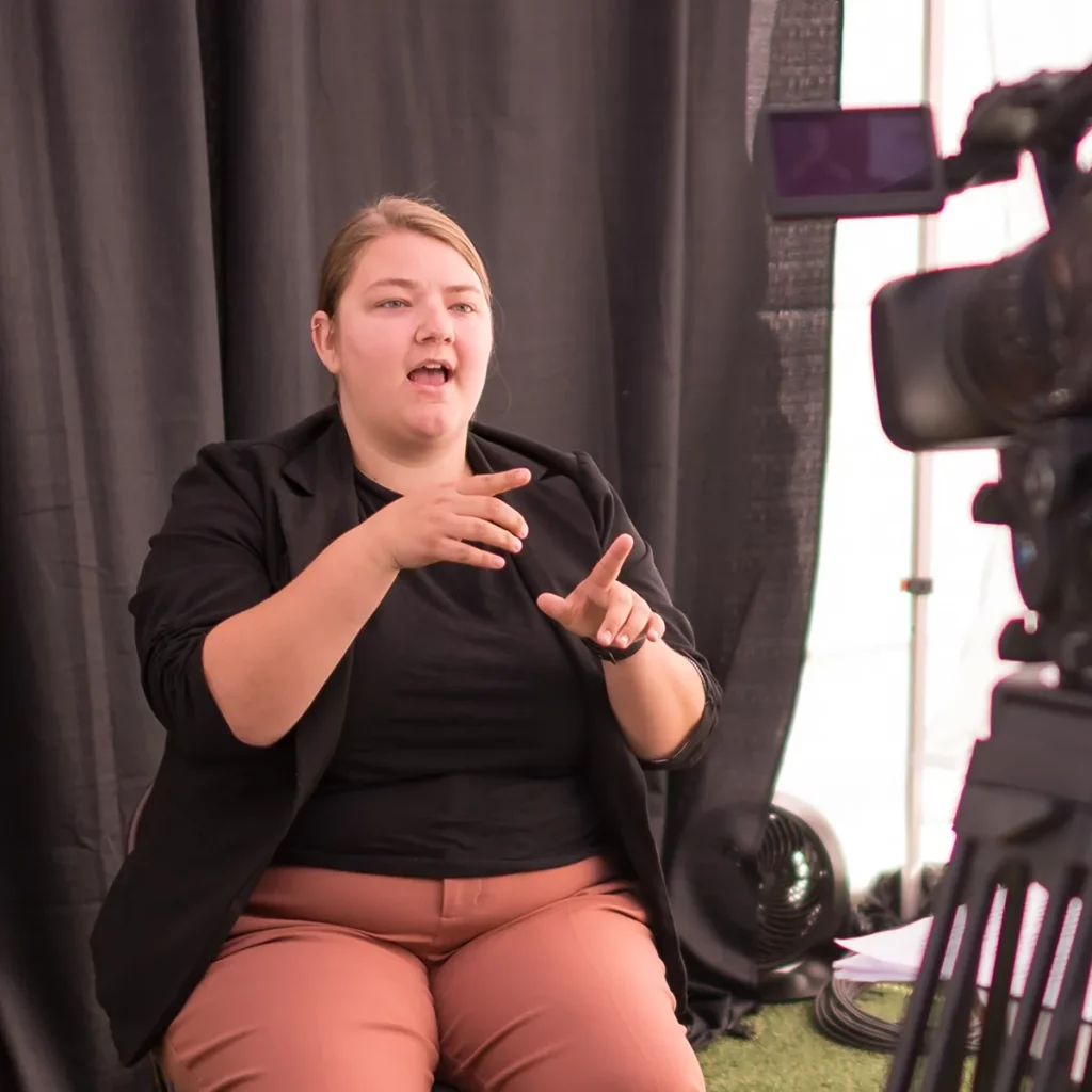 An ASL interpreter signs during a live event.