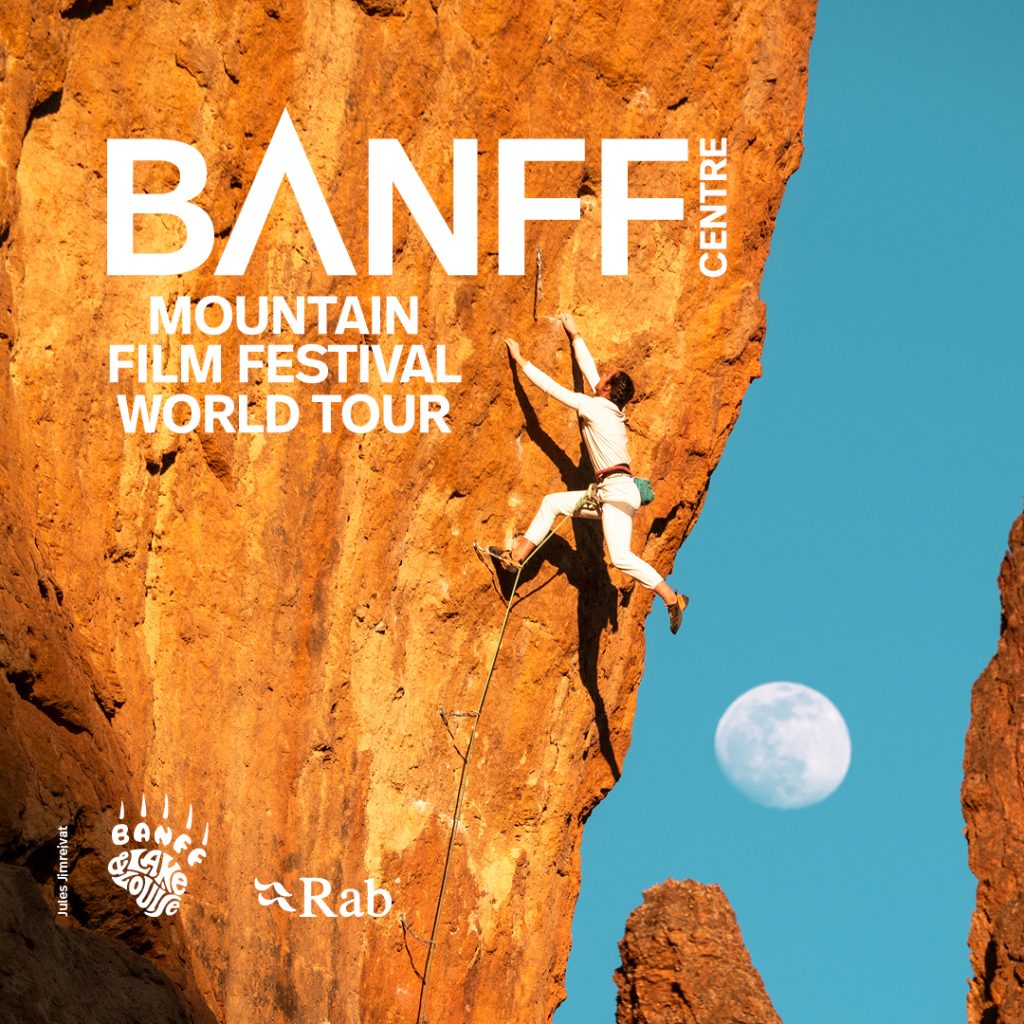 The Banff Mountain Film Festival logo over a photo of a rock climber hanging from an orange colored cliff face, with a blue sky and almost full moon in the background.