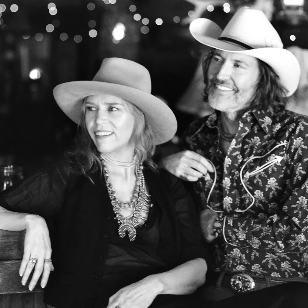 Black and white photo of musicians Gillian Welch and David Rawlings in western wear.